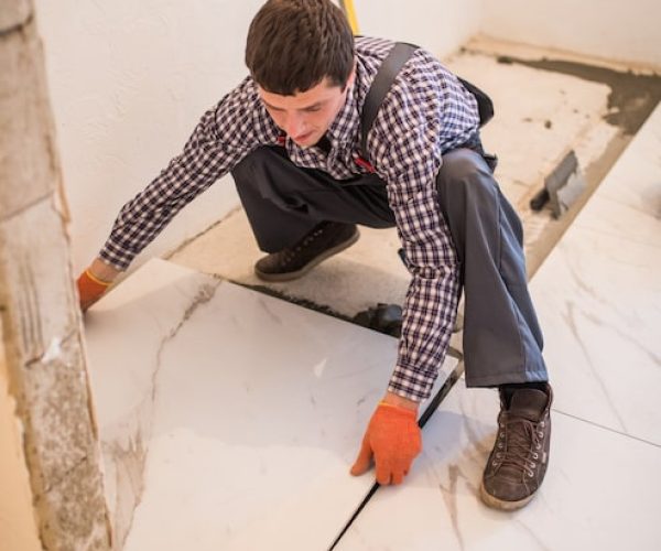 construction-worker-tiler-is-tiling-ceramic-tile-floor-adhesive-laying-ceramic-tiles_231208-6792
